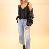 Woman styled in black lace satin Uma cami tucked into jeans for a chic, effortless outfit.