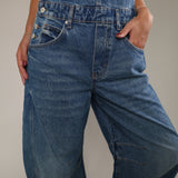 Casual women's denim overalls featuring adjustable shoulder straps, side button details, and a loose, comfortable fit.