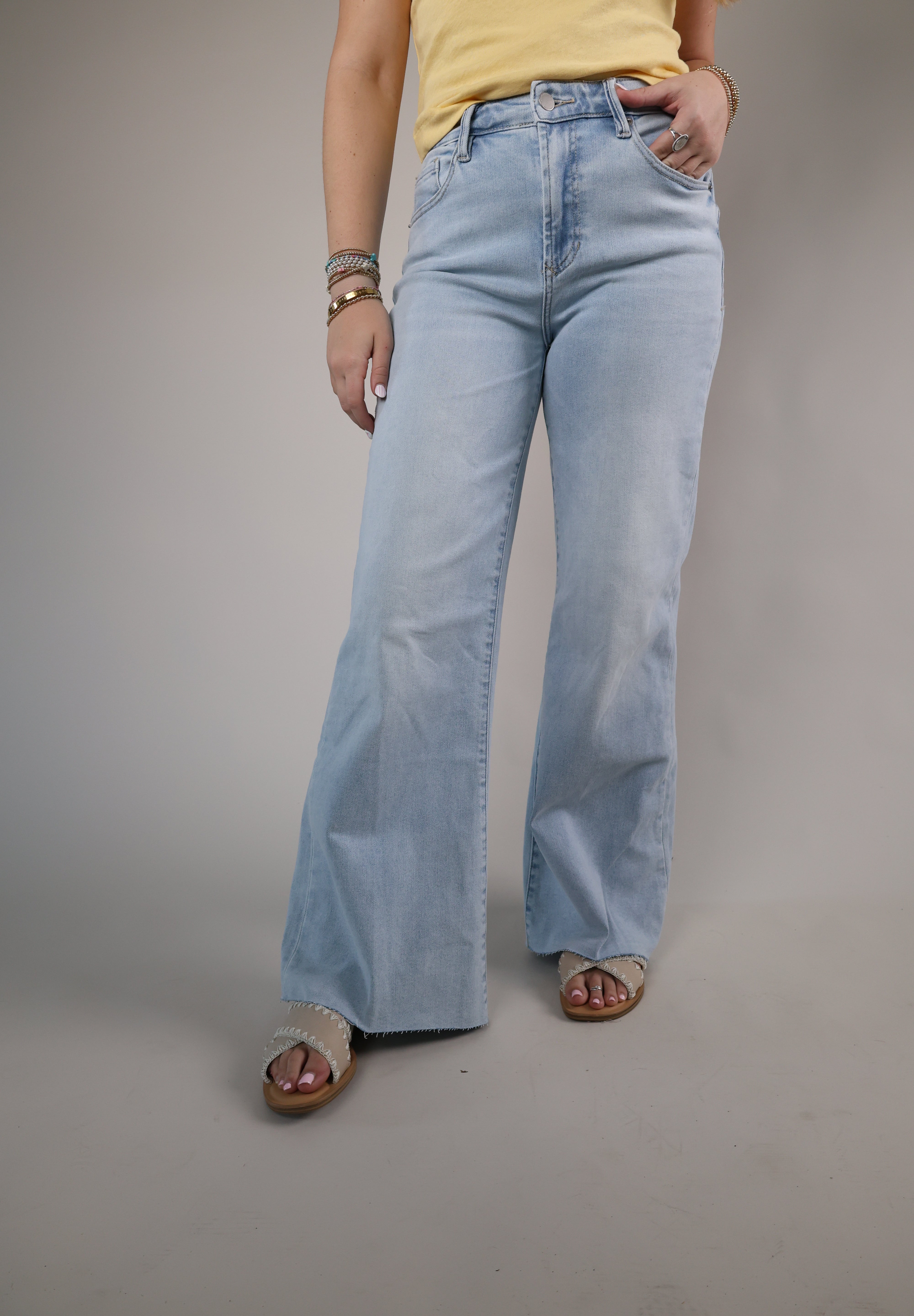 High-waisted light blue denim jeans featuring a wide-leg silhouette, subtle faded wash, and casual chic style.