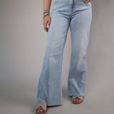 Woman wearing Dear John Fiona Wide Leg Jeans in Raindrop featuring a light wash denim, high-rise waist, and relaxed wide-leg silhouette.