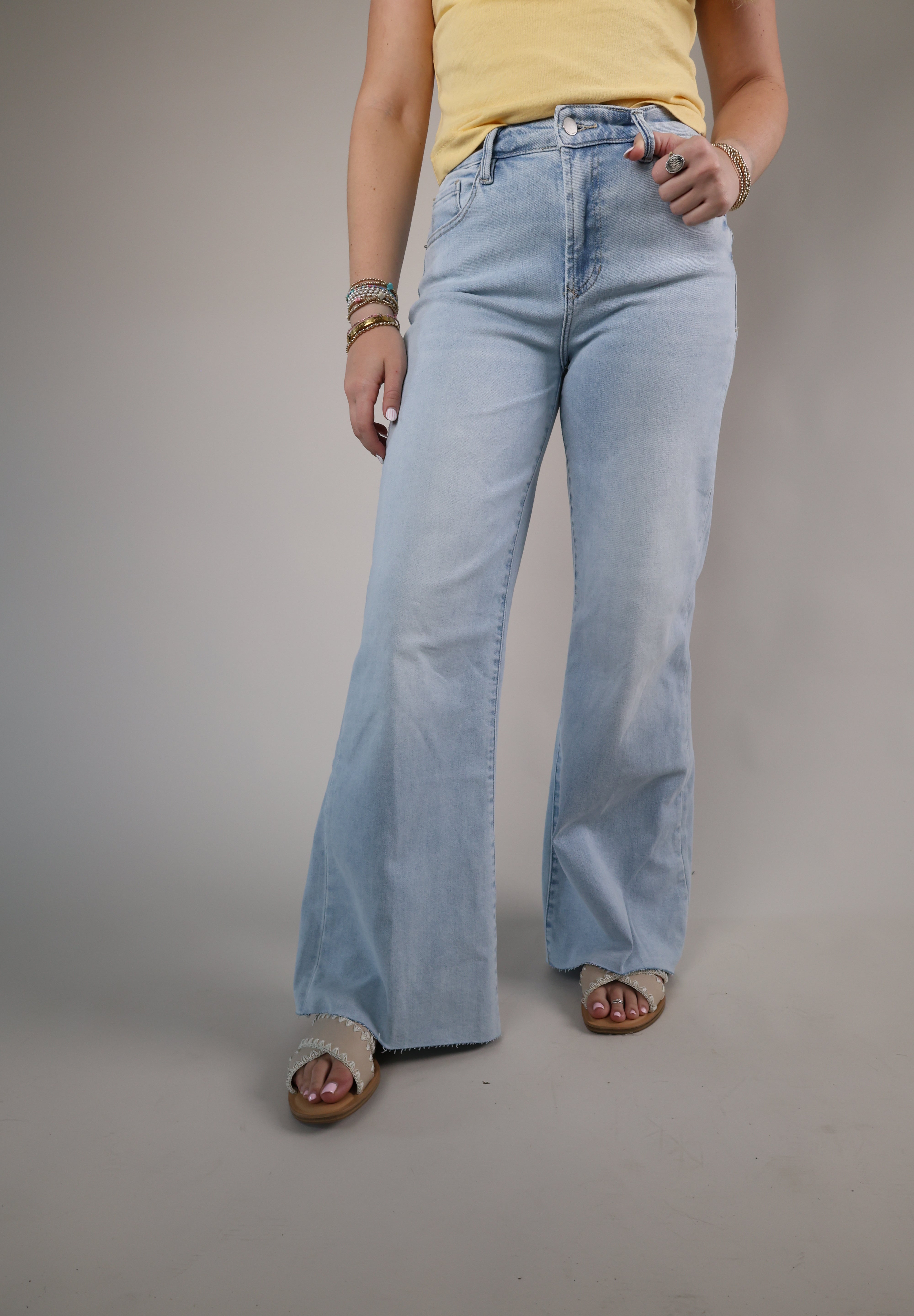 Woman wearing Dear John Fiona Wide Leg Jeans in Raindrop featuring a light wash denim, high-rise waist, and relaxed wide-leg silhouette.
