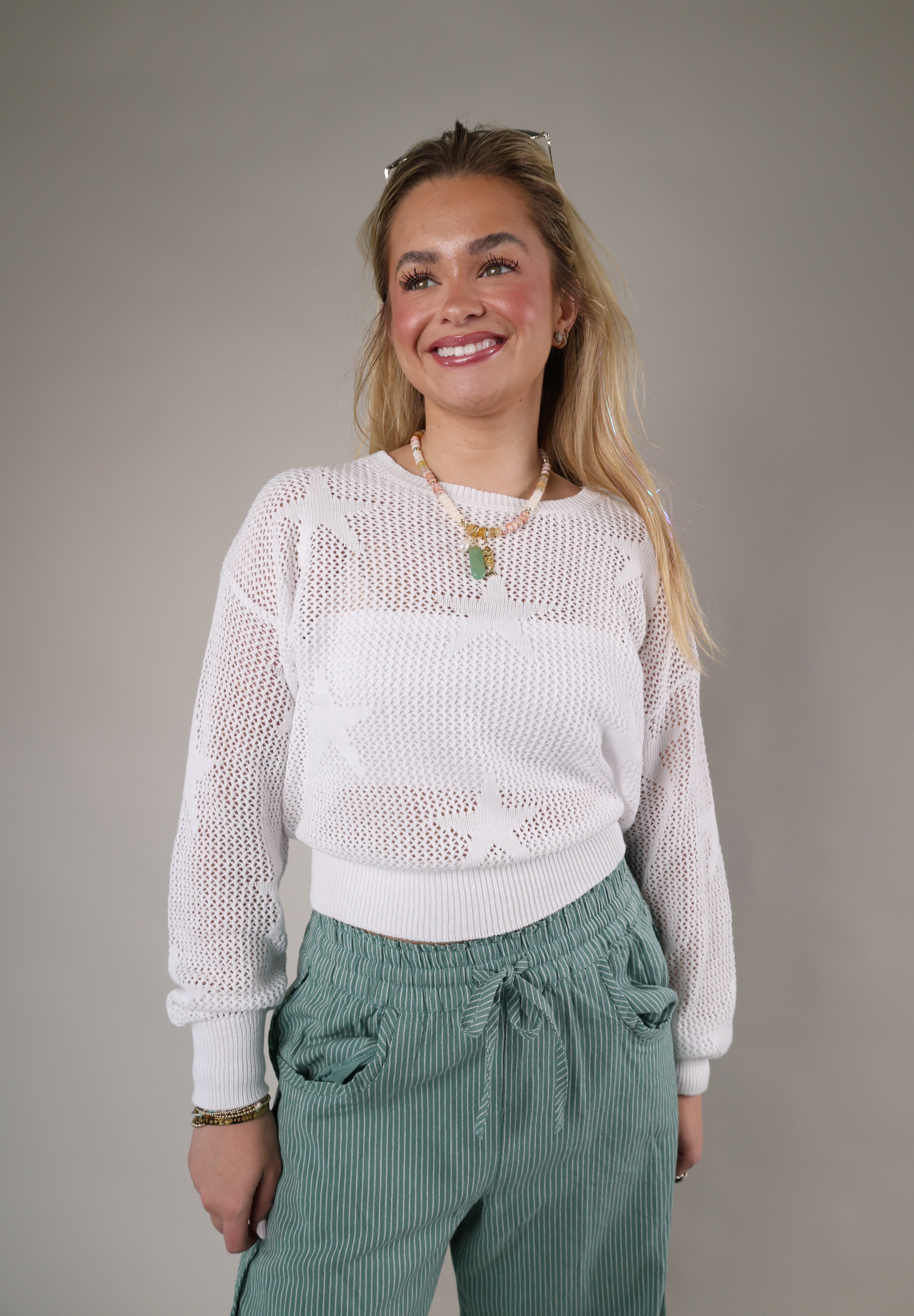 Lightweight white pullover sweater with an open-weave knit texture, crew neckline, and relaxed everyday fit.