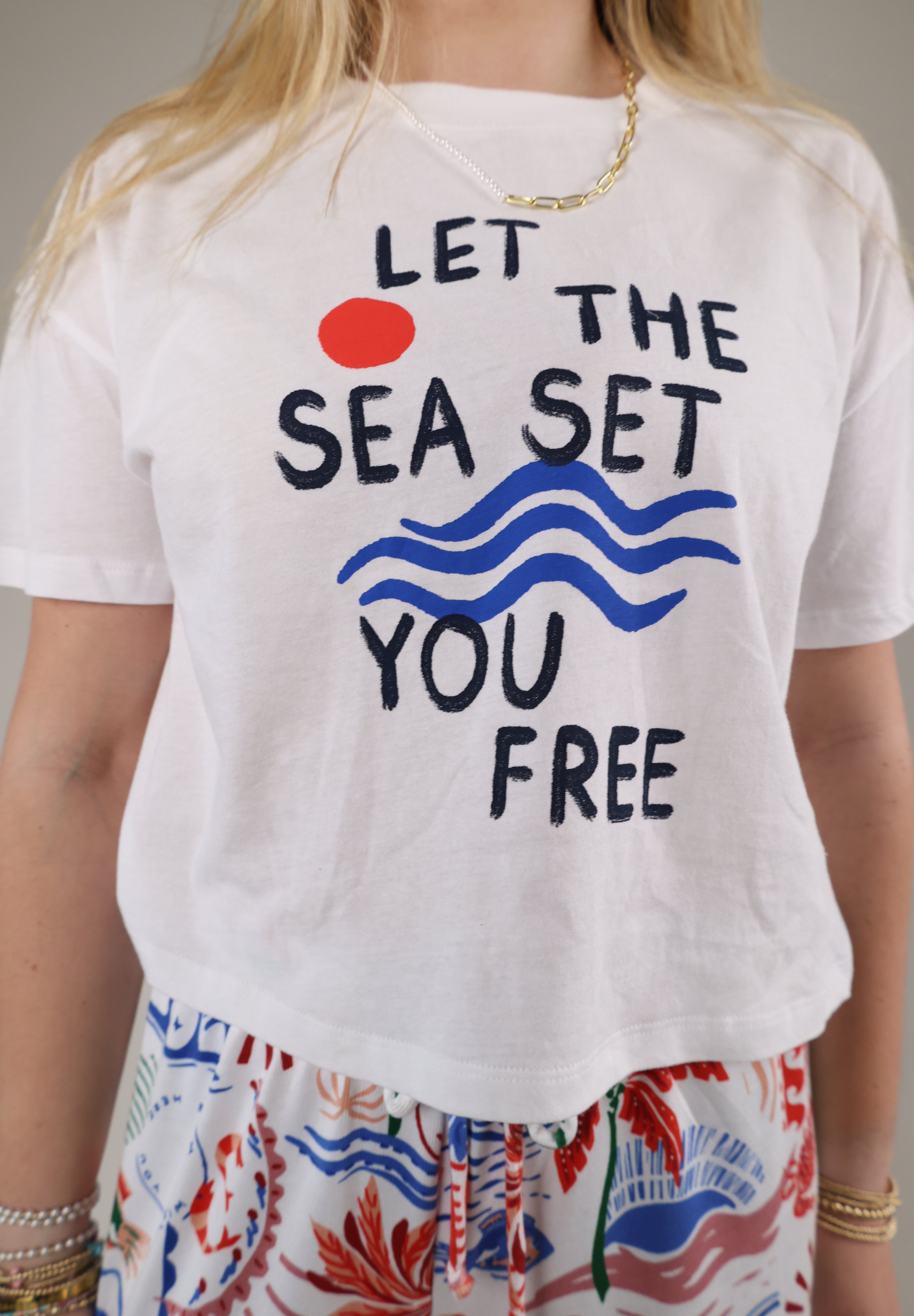 Woman wearing the Z Supply Vintage Sea Tee featuring a relaxed white fit with “Let the Sea Set You Free” graphic artwork.