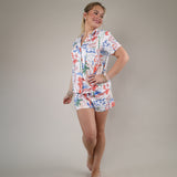 Relaxed fit button-up sleep top featuring a vibrant vacation-inspired print with coral, blue, and green accents.