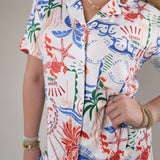 Woman wearing the Z Supply Beach Days Getaway PJ Top featuring a colorful coastal-inspired print and relaxed button-up silhouette.