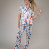 Woman wearing the Z Supply So Sweet Getaway Pants featuring a colorful tropical-inspired print and relaxed straight-leg fit.