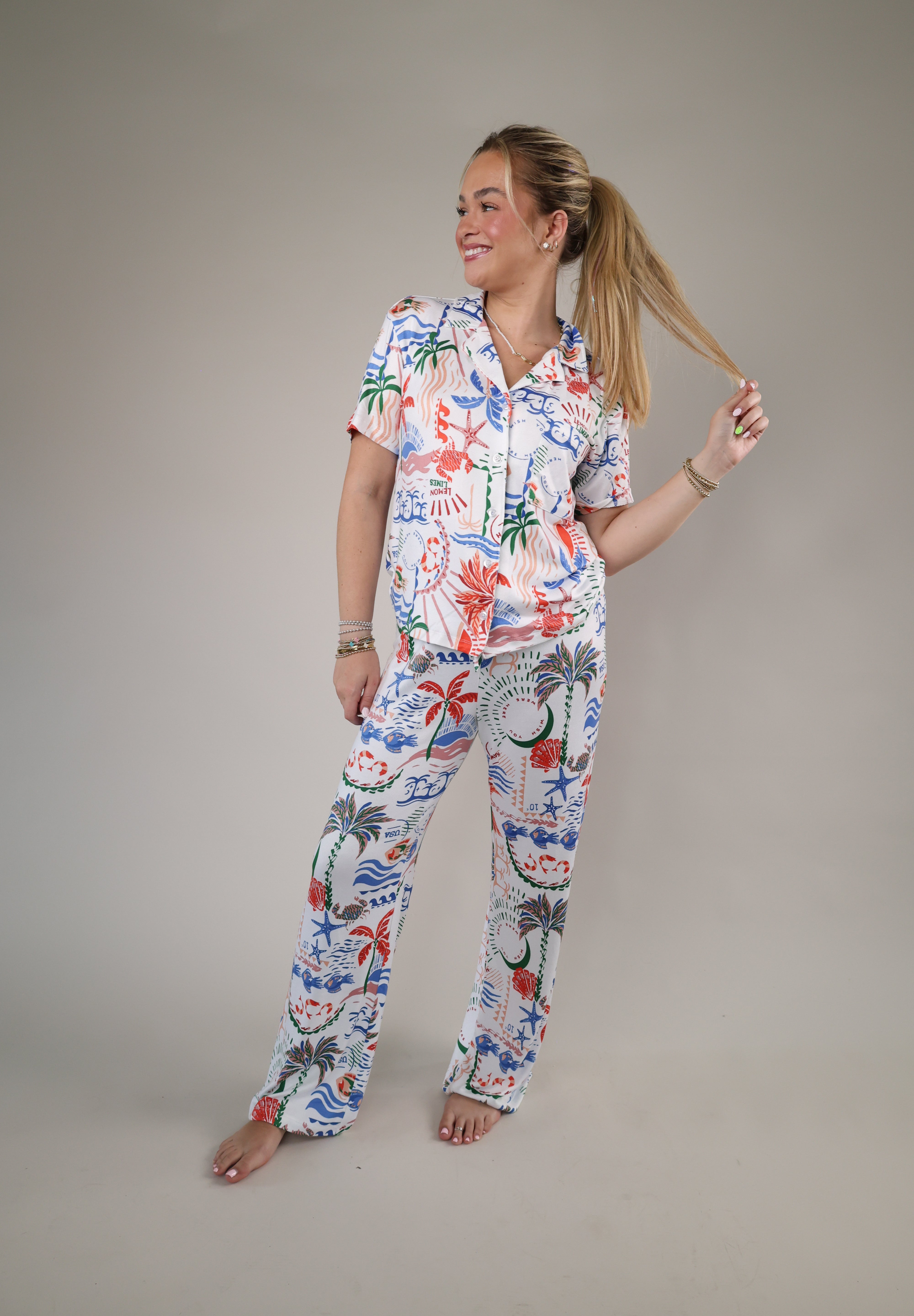 Woman wearing the Z Supply So Sweet Getaway Pants featuring a colorful tropical-inspired print and relaxed straight-leg fit.