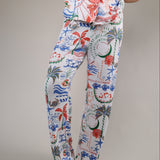 Relaxed fit pajama pants featuring tropical artwork with coral, palm trees, and ocean-inspired accents on a soft white background.