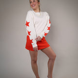Casual oversized Z Supply sweatshirt styled with a bright red skirt, showcasing a soft neutral fabric and playful star print.
