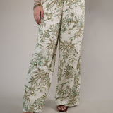 Woman wearing the Z Supply Overlook Tiki Tide Linen Pant featuring a relaxed wide-leg fit and tropical-inspired green leaf print.