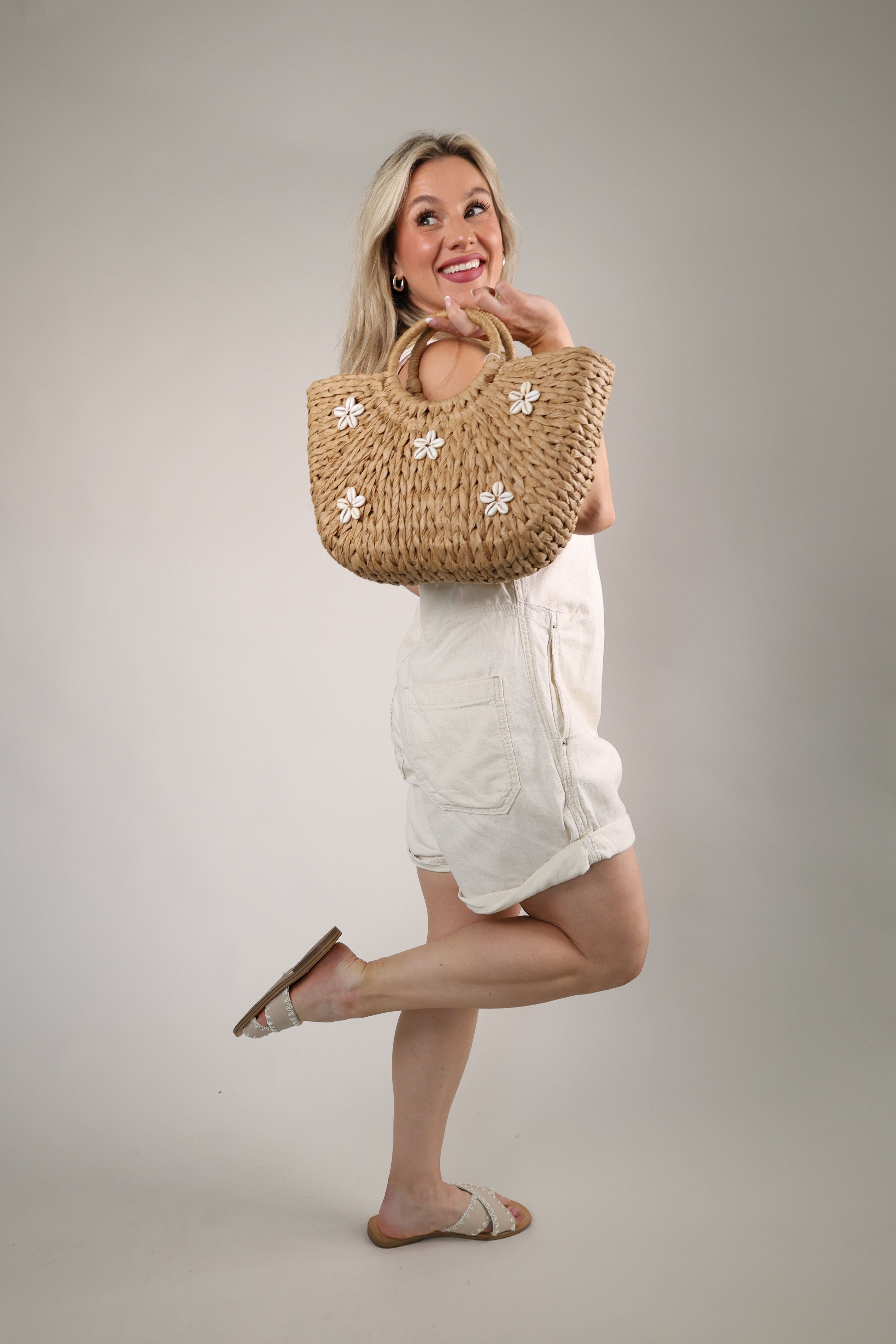 Natural woven Coast Tote bag with shell floral accents and braided handles for summer styling