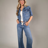 Lightweight structured denim jacket with adjustable side tie detailing perfect for layering over dresses and tanks in summer