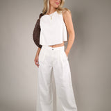 Elegant off white pop over blouse with sleeveless styling and relaxed fit paired perfectly with linen pants for summer fashion