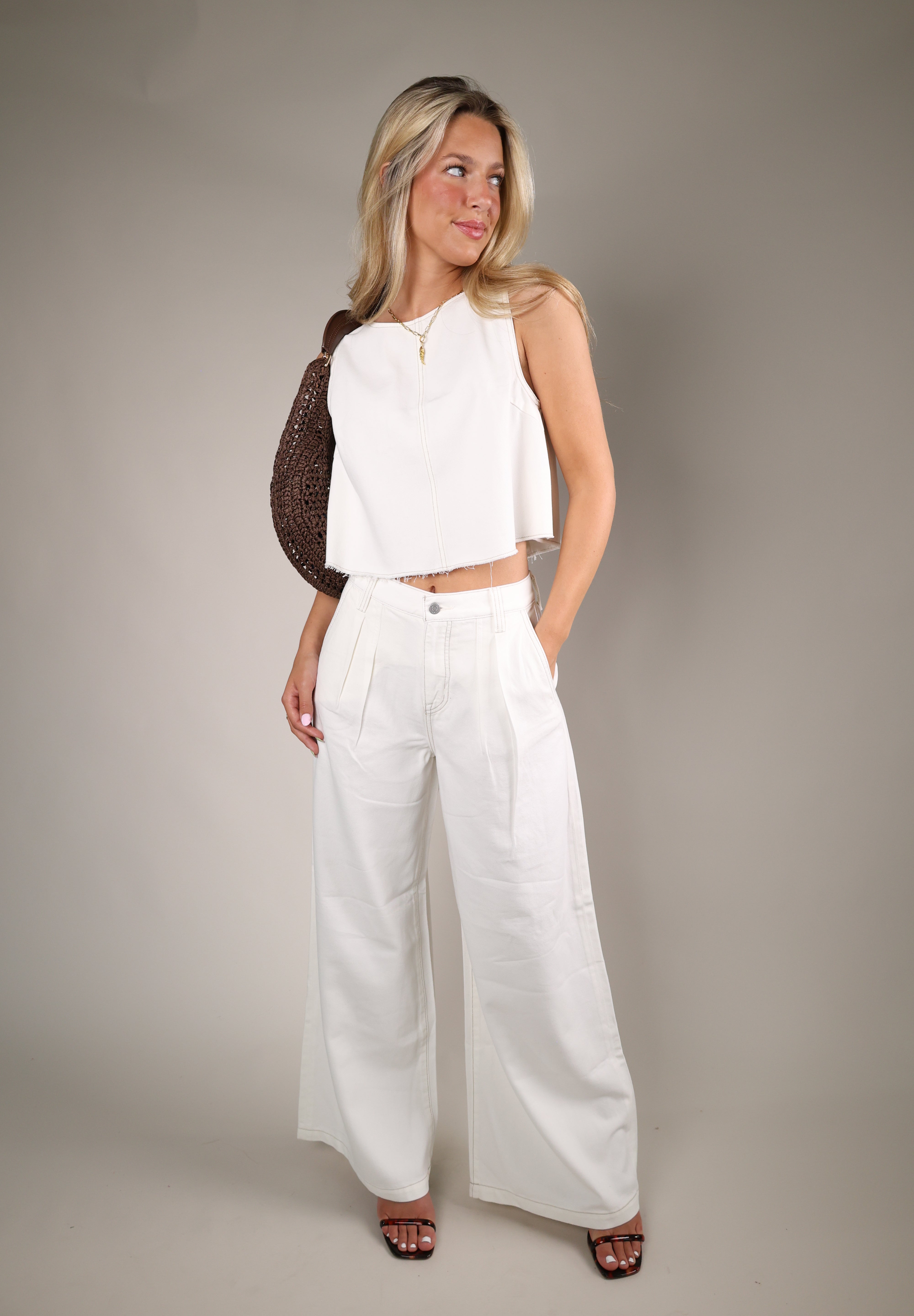 Elegant off white pop over blouse with sleeveless styling and relaxed fit paired perfectly with linen pants for summer fashion