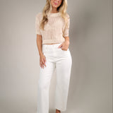 Lightweight crewneck knit sweater styled with denim and linen pants for an elevated casual summer look